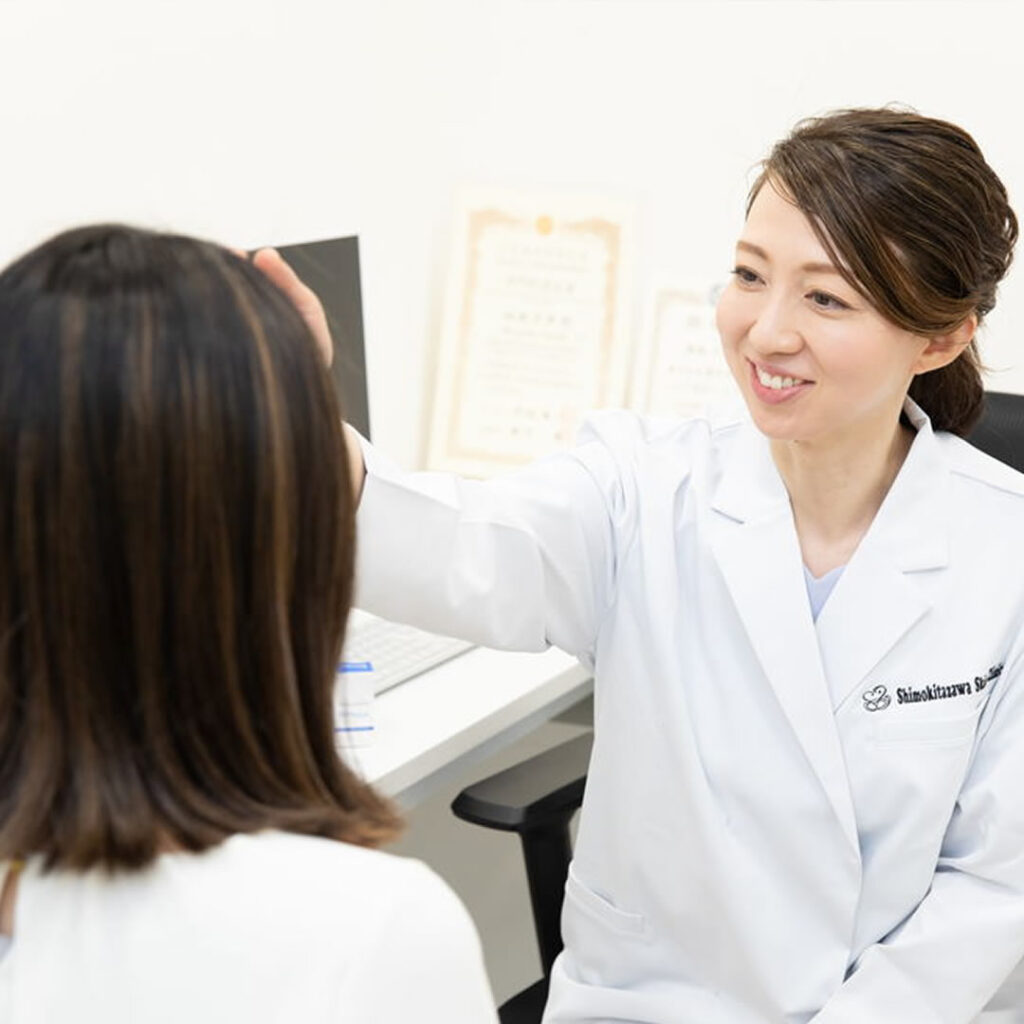 かゆみで悩む女性の話を聞いている女医